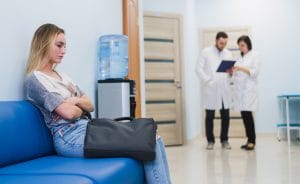 Woman patient waiting at hospital while doctors talking