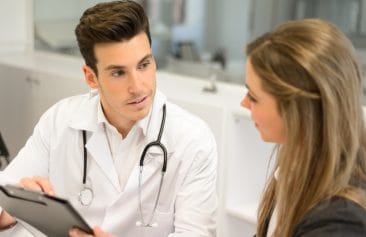Doctor listening to patient explaining her painful in his office