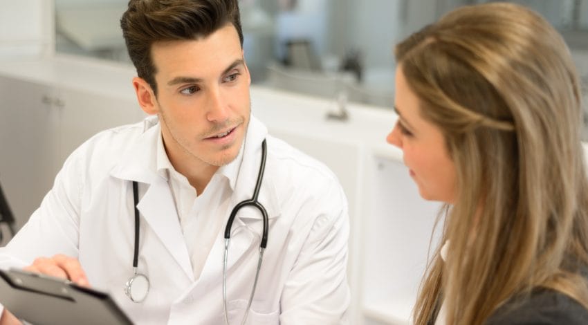 Doctor listening to patient explaining her painful in his office