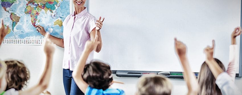 Teacher teaching kids in classroom at school